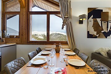 A bed with white sheets and pillows in a hotel room