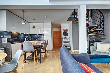 A living room with a spiral staircase leading up to the second floor
