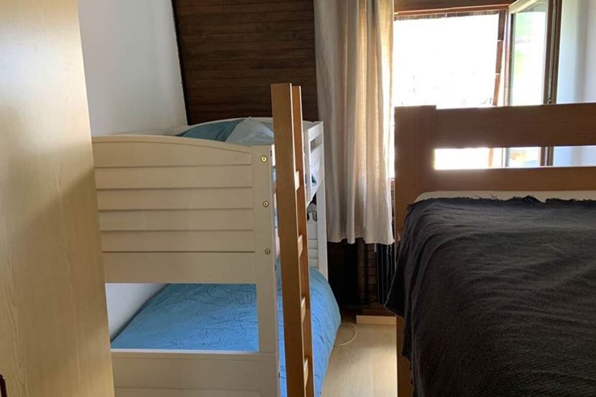 A bedroom with a bunk bed and a bed