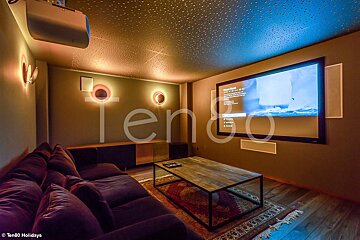 A home theater with a large screen and the word tengo on the wall
