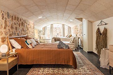 A bedroom with a large bed and a rug