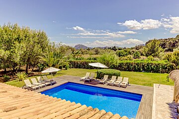 A large swimming pool surrounded by chairs and umbrellas