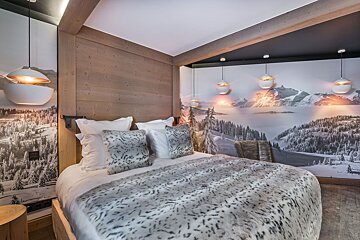 A bedroom with a bed and a painting of mountains on the wall