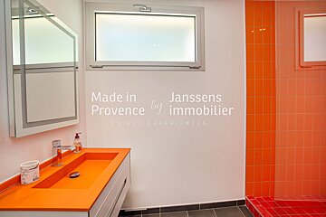 A bathroom with orange tiles and a sink that says made in provence by immobilier