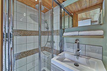 A bathroom with a sink and a walk in shower
