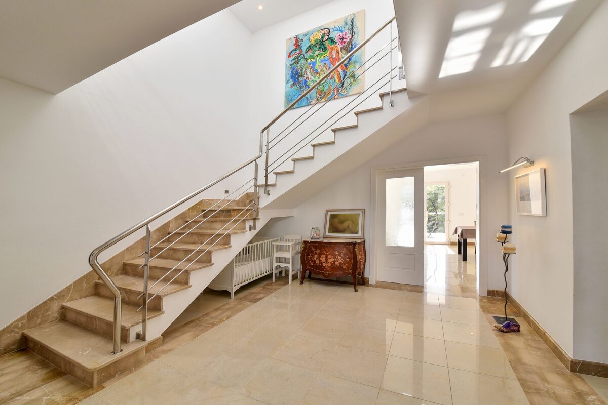 A staircase with a painting on the wall above it