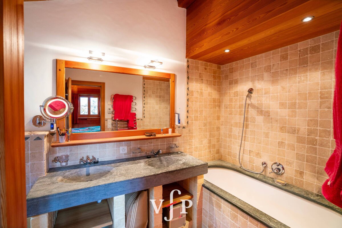 A bathroom with a bathtub and a sink with the letter v on the bottom