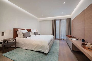 A bedroom with a large bed and a desk