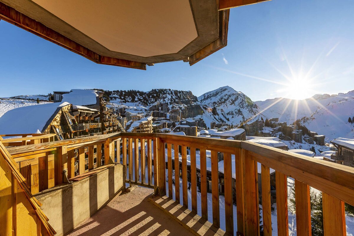 The sun is shining brightly over the snowy mountains