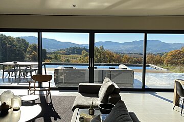 A living room with a view of mountains and trees