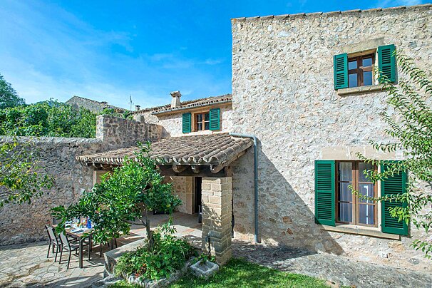 A stone building with green shutters on the windows