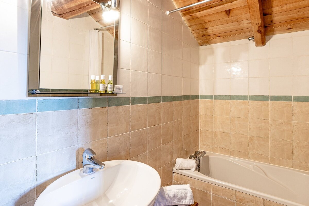 A bathroom with a sink a bathtub and a mirror