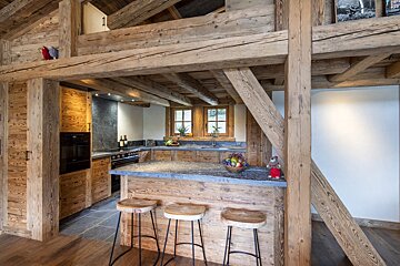 A kitchen with wooden cabinets and a marble counter top