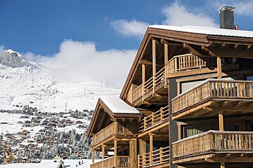 A large wooden building with a mountain in the background