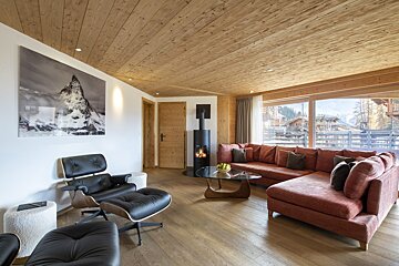 A living room with a red sectional couch and a black chair