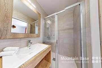 A bathroom with a sink and a shower says mountain base immobilier real estate