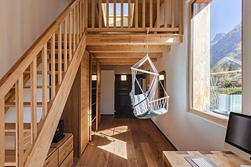 A wooden staircase with a hammock hanging from it
