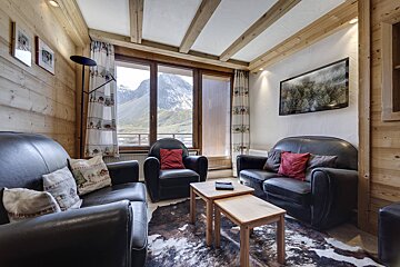 A living room with a couch a chair and a flat screen tv