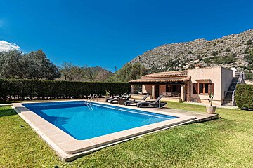 A house with a large swimming pool in front of it