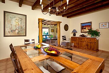 A dining room table with a bowl of fruit on it