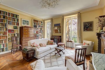 A living room with a white couch and lots of bookshelves