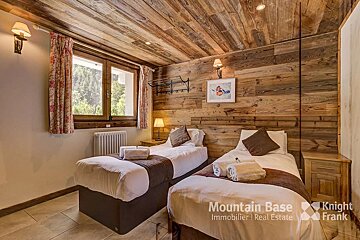 A bedroom with two beds and a sign that says mountain base