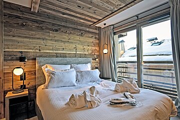 A bedroom with a large bed and a large window