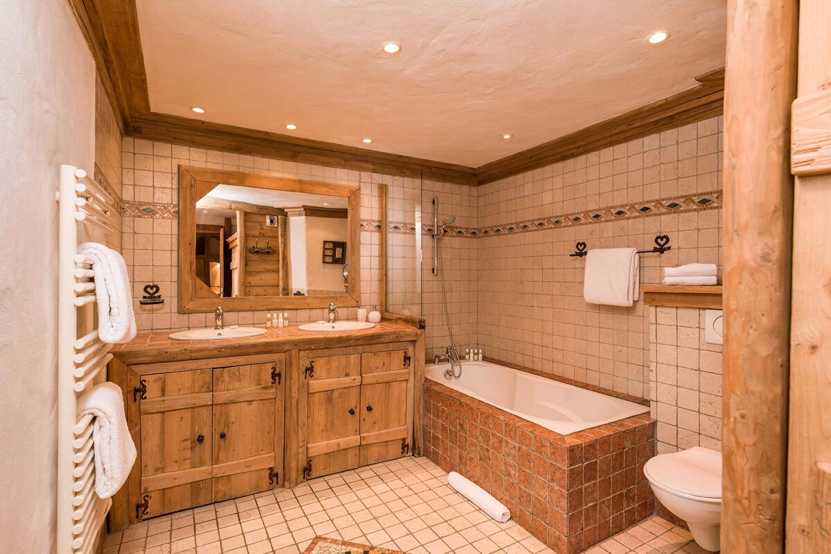 A bathroom with two sinks a toilet and a bathtub