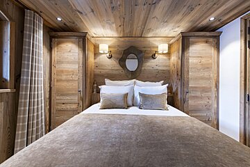 A bedroom with a bed and a mirror on the wall