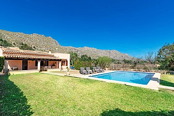 A house with a large swimming pool in front of it