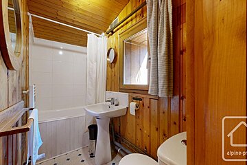 A bathroom with wood paneling and a toilet and sink