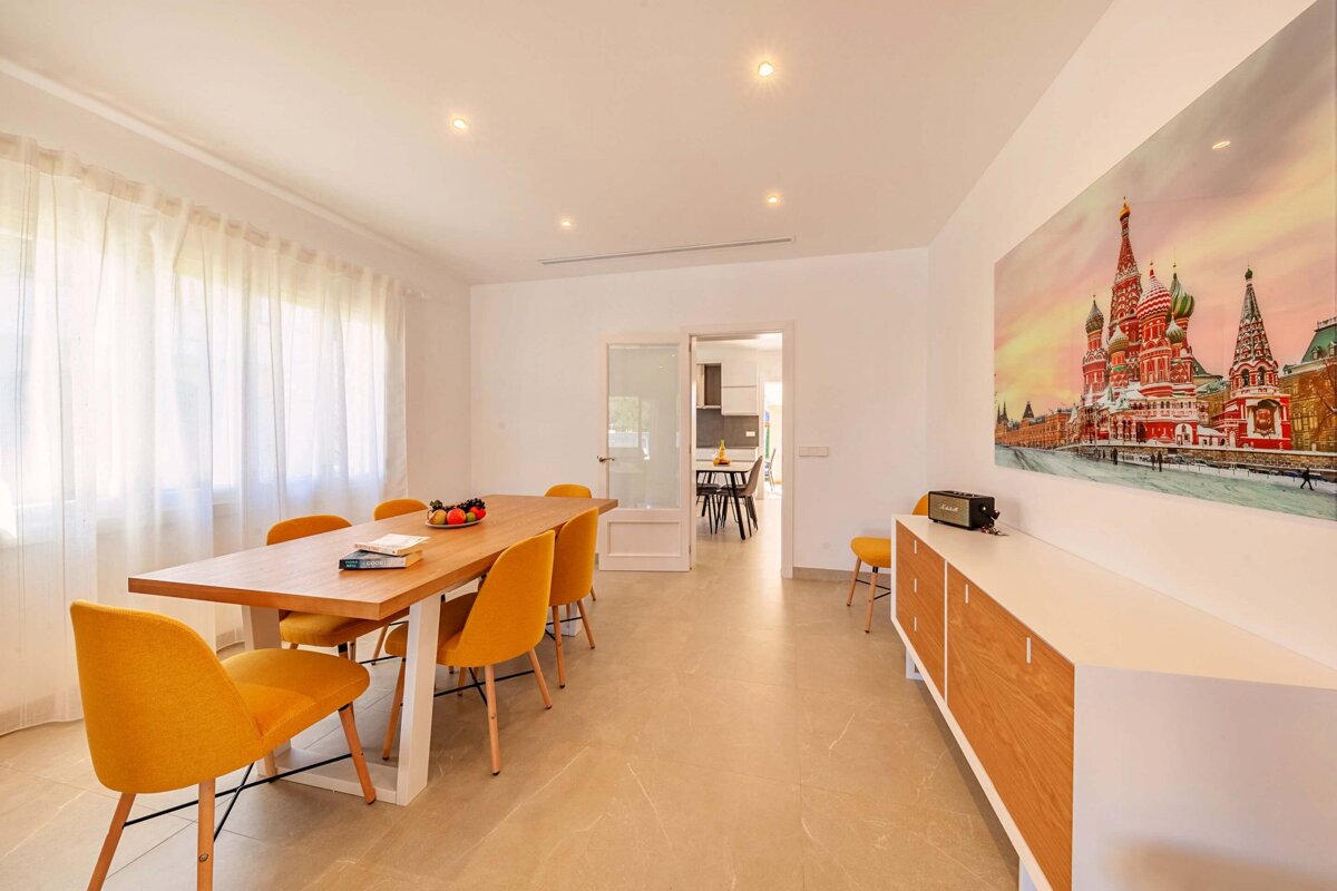 A room with a table and chairs and a painting on the wall