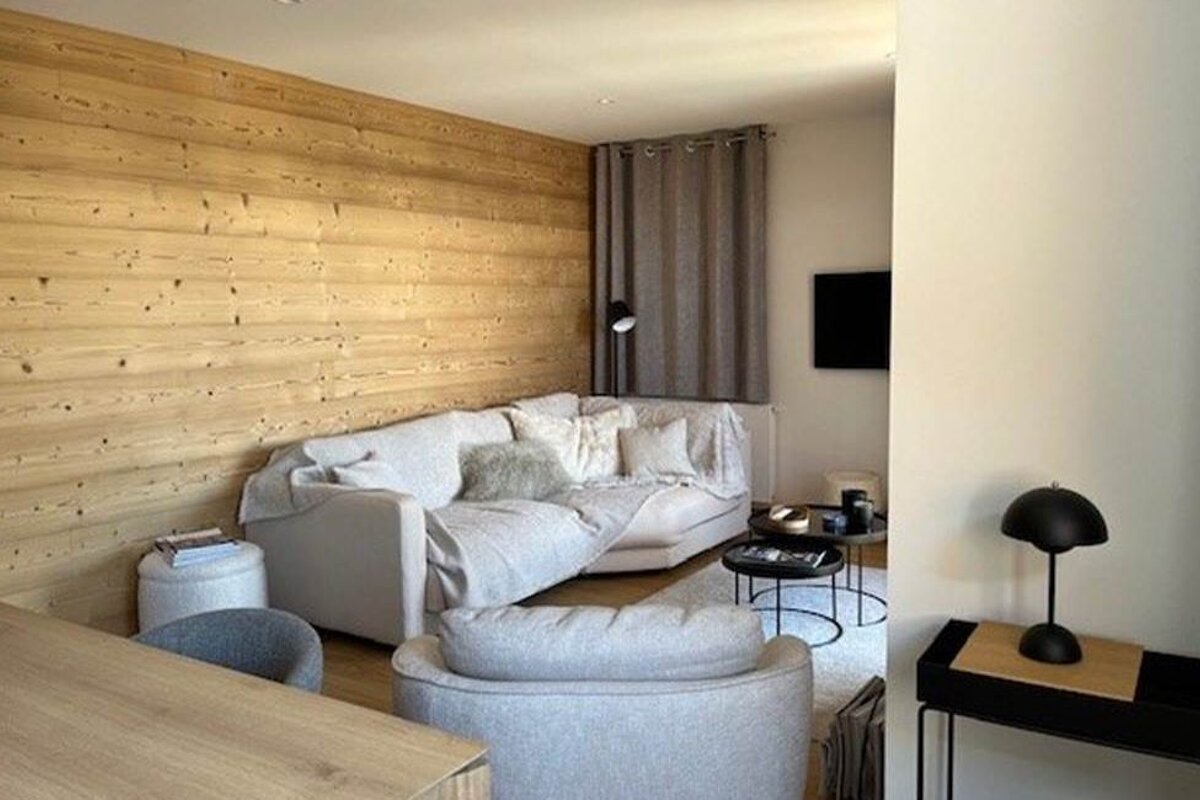 A living room with a white couch and a wooden wall