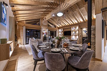 A dining room table with a bottle of wine on it