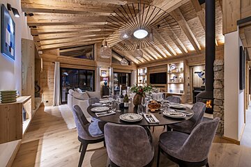 A dining room table with a bottle of wine on it