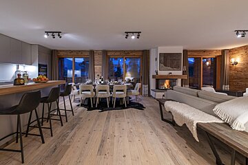 A living room with a dining table and chairs and a fireplace