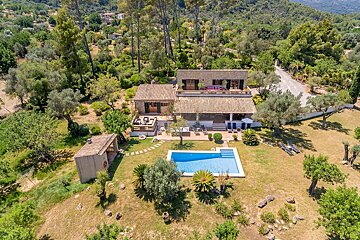 An aerial view of a house with a large swimming pool
