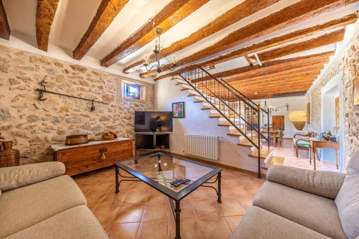 A living room with a staircase leading up to the second floor