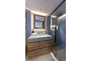 A bathroom with a sink a mirror and a shower