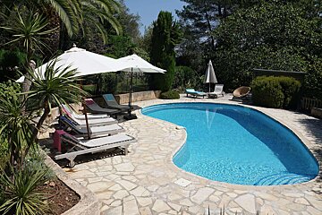 A large swimming pool surrounded by chairs and umbrellas