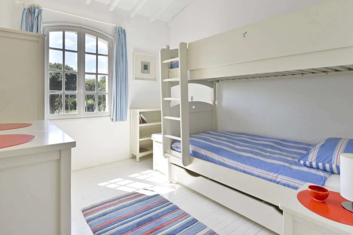 A bedroom with a bunk bed and a window
