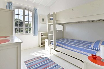 A bedroom with a bunk bed and a window