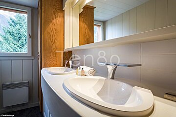A bathroom with two sinks and a sign that says ten80