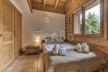 A bedroom with a bed and a window that says ten80