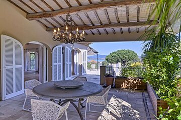 A patio with a table and chairs and a chandelier