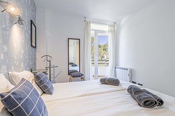 A bedroom with two beds and a large window