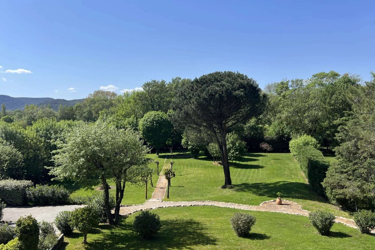 A large lush green field with trees and bushes