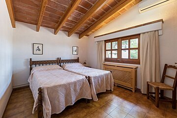 A bedroom with two twin beds and a chair