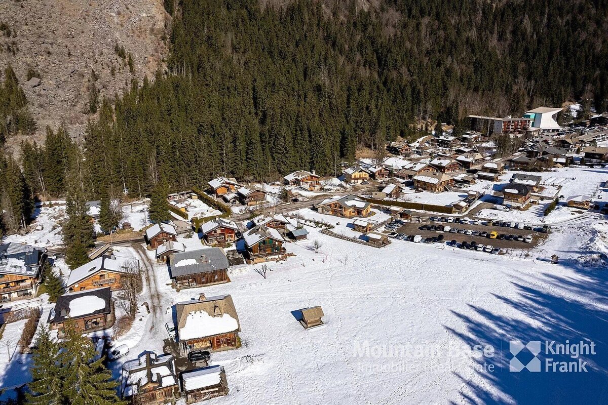 An aerial view of a snowy village with knight frank written on the bottom