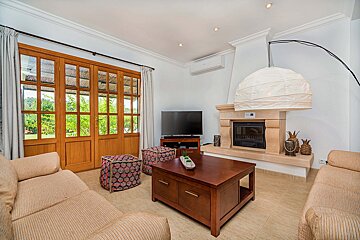 A living room with a fireplace and a flat screen tv